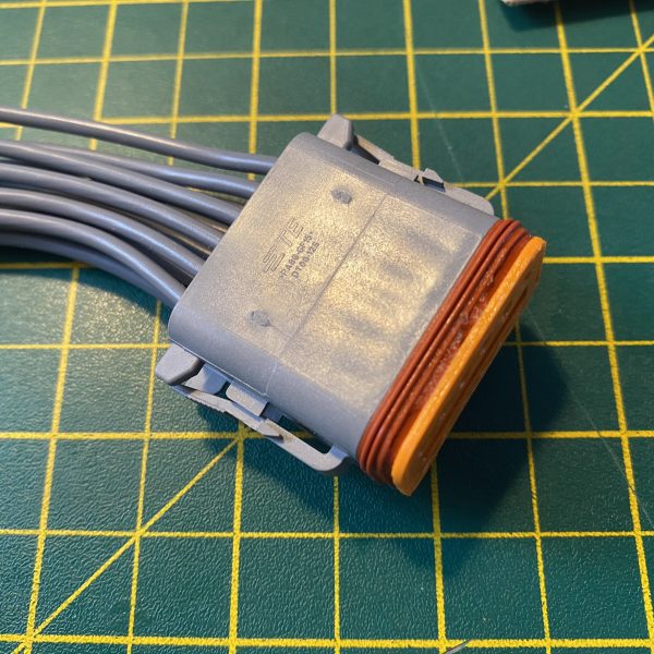 Deutsch DT06-12S-C015 12-way socket plug rear view showing grey housing with TE Connectivity markings and orange C015 E-seal fully seated — Voltforge 430019-000